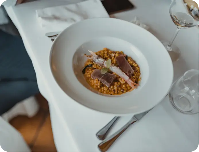 Primo piatto di fregula sarda con gambero, tonno e condimenti, servito nel ristorante del Myo Hotel Rocce Sarde.